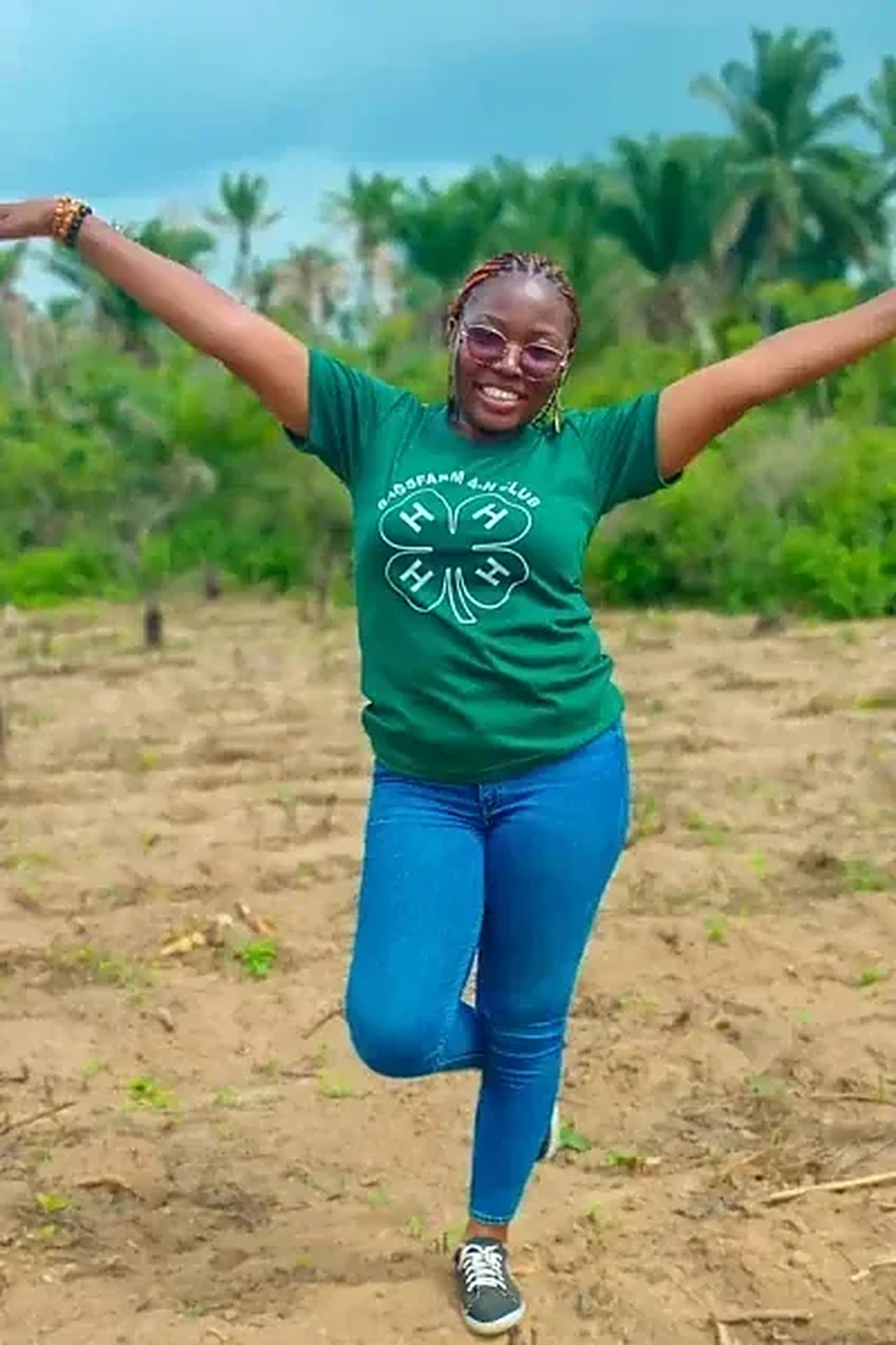 BANI team member in 4-H shirt on the farm