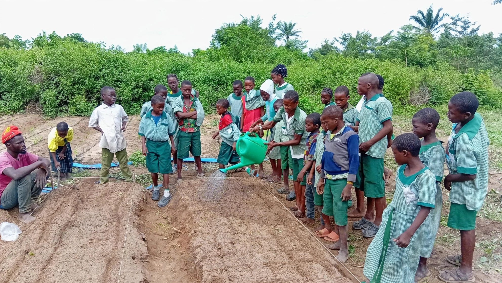 Students gathered around a garden bed during training